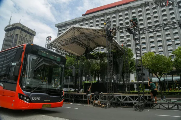 Aktivitas pekerja saat menyelesaikan pembangunan panggung hiburan rakyat di beberapa titik yang disaksikan oleh sejumlah pengunjung di kawasan Monumen Nasional (Monas) di Jakarta, Minggu, 29 Desember 2024. ( Poskota/ Ahmad Tri Hawaari)