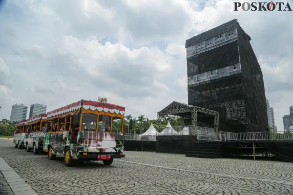 Aktivitas pekerja saat menyelesaikan pembangunan panggung hiburan rakyat di beberapa titik yang disaksikan oleh sejumlah pengunjung di kawasan Monumen Nasional (Monas) di Jakarta, Minggu, 29 Desember 2024. ( Poskota/ Ahmad Tri Hawaari)