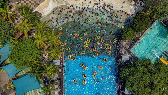 Foto udara dan para pengunjung saat menikmati sejumlah wahana air 'Atlantis' di destinasi liburan keluarga Ancol Taman Impian, Jakarta Utara, Minggu, 29 Desember 2024. (Poskota/ Ahmad Tri Hawaari)