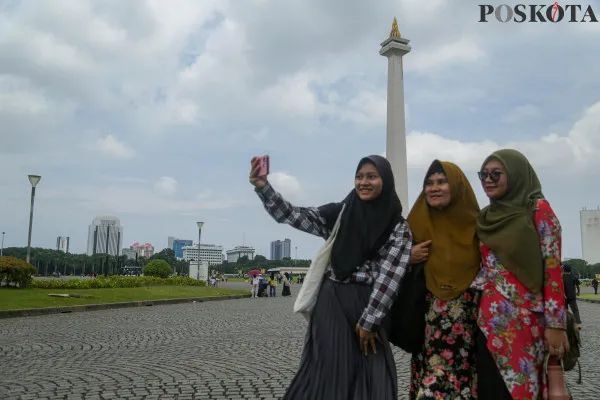 Sejumlah pengunjung saat berlibur memadati kawasan Monumen Nasional, Gambir, Jakarta Pusat, Minggu, 29 Desember 2024. (Poskota/ Ahmad Tri Hawaari)