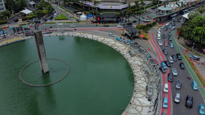 Aktivitas pekerja saat menyelesaikan pembangunan panggung hiburan rakyat di beberapa titik yang disaksikan oleh sejumlah pengunjung di kawasan Monumen Nasional (Monas) di Jakarta, Minggu, 29 Desember 2024. ( Poskota/ Ahmad Tri Hawaari)