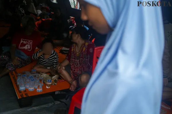 Aktivitas warga saat berada di Posko pengungsian kebakaran yang terjadi di pemukiman padat penduduk RT 10 RW 01 Kebon Manggis, Matraman, Jakarta Timur, Jumat, 6 Desember 2024. (Poskota/ Ahmad Tri Hawaari)