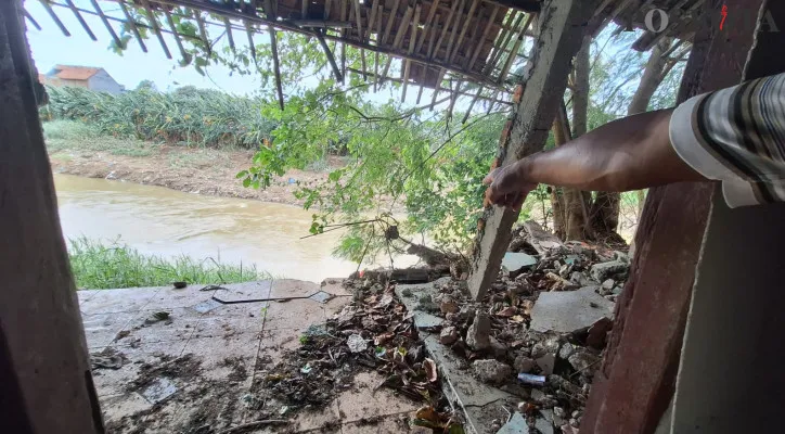 Area belakang rumah Slamet rusak dan beririsan dengan Kali Bekasi, di Kampung Warung Pojok, Kelurahan Kebalen, Kecamatan Babelan, Kabupaten Bekasi, Selasa, 3 Desember 2024. (Poskota/Ihsan)