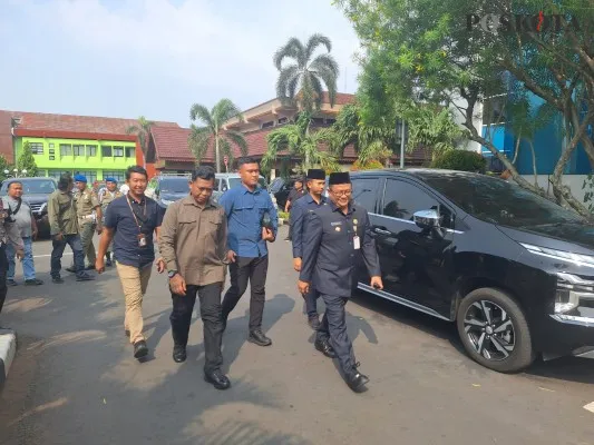 Pj Wali Kota Bekasi, Raden Gani Muhammad (tampak depan memakai kopiah hitam) saat berada di Pemkot Bekasi. (Poskota/Ihsan)