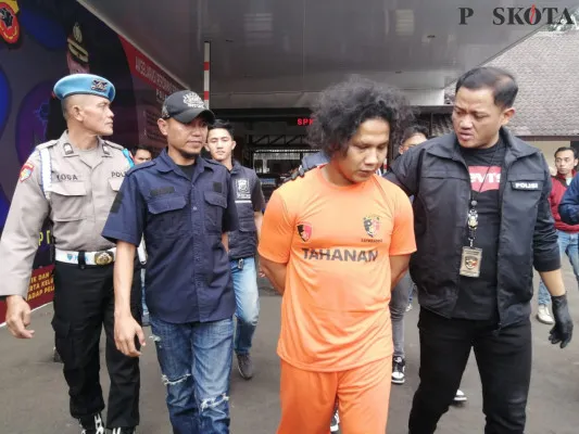 Polisi mengamankan tersangka SR (baju oranye), yang merupakan pelaku pembunuhan terhadap istrinya di Kota Cimahi. (Poskota/Gatot Poedji)