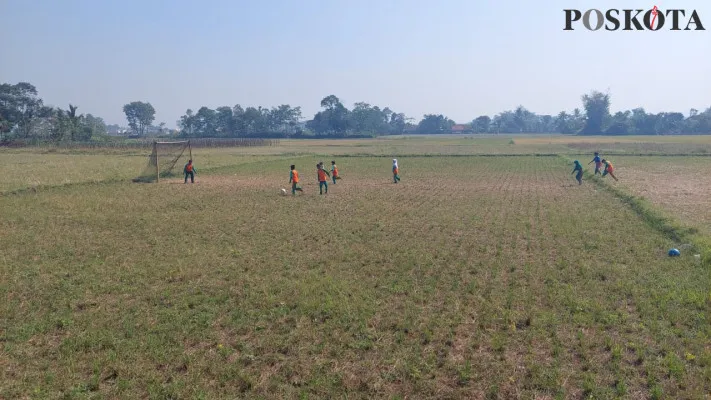 Anak-anak memanfaatkan lahan pesawahan yang mengalami kekeringan di kawasasan Batujajar Kabupaten Bandung Barat sebagai tempat bermain. (Poskota/Gatot Poedji Utomo)