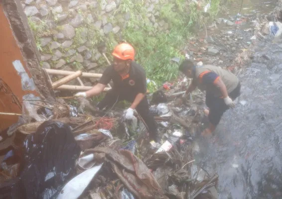 Petugas BPBD Kota Sukabumi membersihkan saluran sungai dari sampah yang menyumbat menyebabkan banjir bandang. (Dok BPBD Sukabumi)