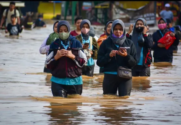 Sejumlah pekerja pabrik melintasi Jalan Dayeuhkolot yang tergenang banjir, Sabtu 23 November 2024. (Instagram @info.baleendah)