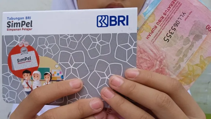 Seorang siswa SD memperlihatkan saldo dana Rp450.000 beserta buku rekening SimPel BRI dari bansos PIP yang diterimanya. (Poskota/Neni Nuraeni)