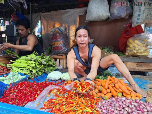 Sofyan pedagang sayur mayur di Pasar Baru Bekasi, menunjukkan cabai yang harganya mengalami kenaikan hampir dua kali lipat jelang tahun baru, Senin, 30 Desember 2024. (Poskota/Ihsan Fahmi)