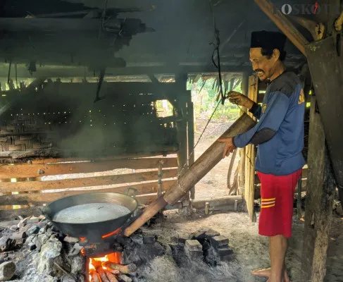 Juarta sedang mengaduk air nira hasil sadapan untuk dijadikan gula aren. (Poskota/Samsul Fathony)