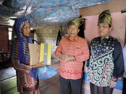 Foto : Direktur Pemberdayaan Zakat dan Wakaf Kementerian Agama (Kemenag) RI, Tarmizi Tohor menyerahkan bantuan kepada salah seorang warga di Desa Sungai Cina, Kecamatan Rangsang Barat, Kabupaten Kepulauan Meranti. (Ist.)