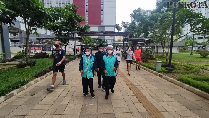 Pasien isolasi Covid-19 di RSDC Wisma Atlet sedang melakukan aktifitas olahraga jalan santai dan jogging di area halaman pada pagi hari. foto: Poskota.co.id (Firas Dalil)