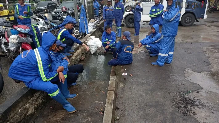 Foto: Petugas Suku Dinas Sumber Daya Air saat sedang membersihkan saluran di kawasan Green Garden, Kedoya Utara, Kebon Jeruk, Jakarta Barat. (Poskota/Pandi)