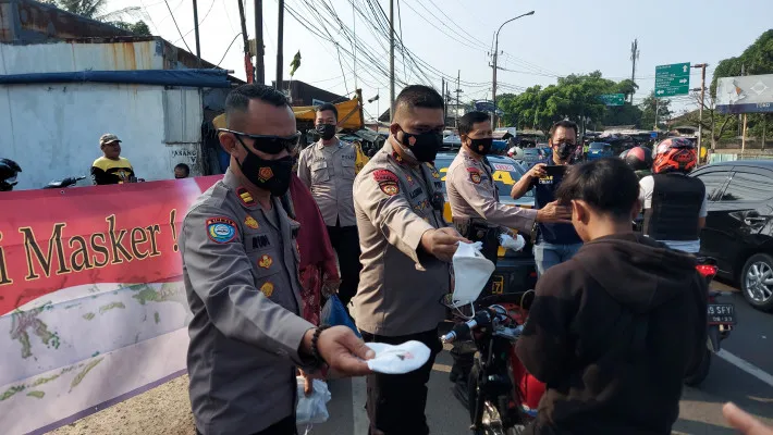 Kapolsek Cimanggis Kompol Ibrahim Joao Sadjab didampingi Kanit Binmas Iptu Rudy dalam kegiatan bagi-bagi masker di Pasar Cisalak. (angga)