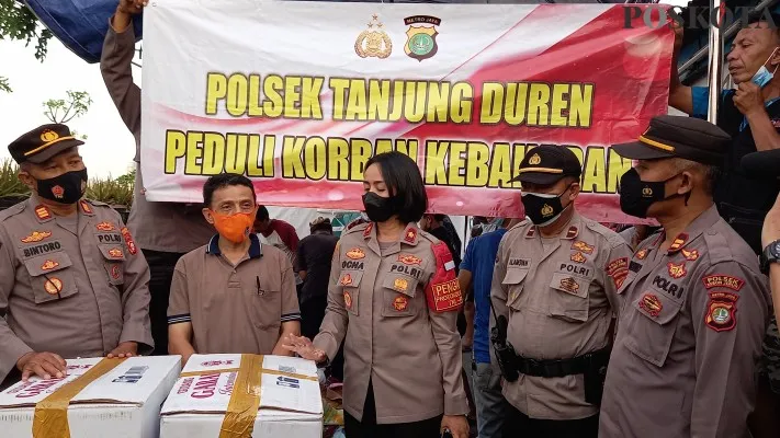 Polsek Tanjung Duren membagikan bantuan pakaian layak pakai bagi korban terdampak kebakaran di Grogol Petamburan, Jakarta Barat, Kamis (12/8/2021). (cr01)