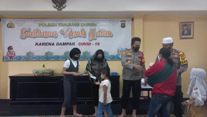 Jajaran Polsek Tanjung Duren saat membagikan sembako dan uang tunai kepada anak yatim korban Covid-19, Sabtu (20/11/2021). (cr01)