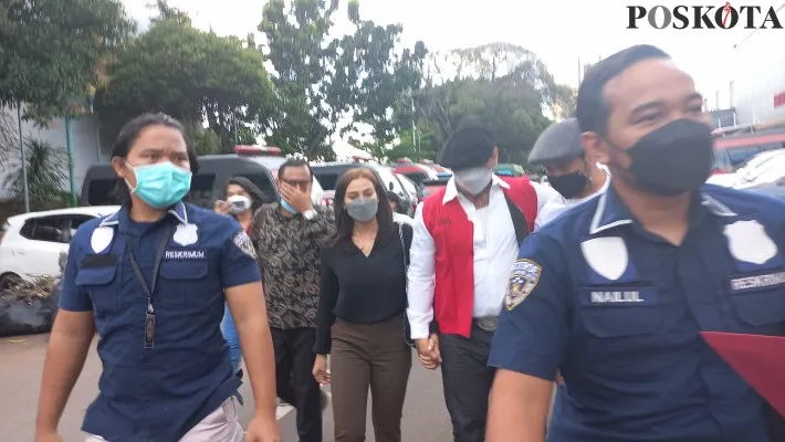 Jerinx dengan mengenakan rompi tahanan berwarna merah ditemani istrinya, Nora Alexandra saat berada di Polda Metro Jaya. (cr01)