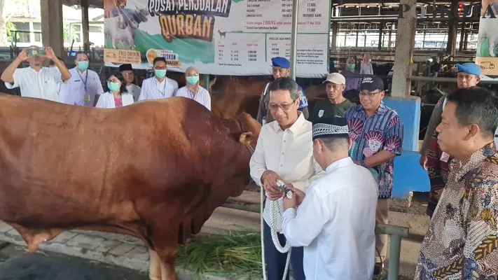 Pj Gubernur DKI Jakarta Heru Budi Hartono secara simbolis memberikan sapi untuk dikurbankan dan dagingnya diberikan ke masyarakat. (Poskota/Pandi Ramedhan)