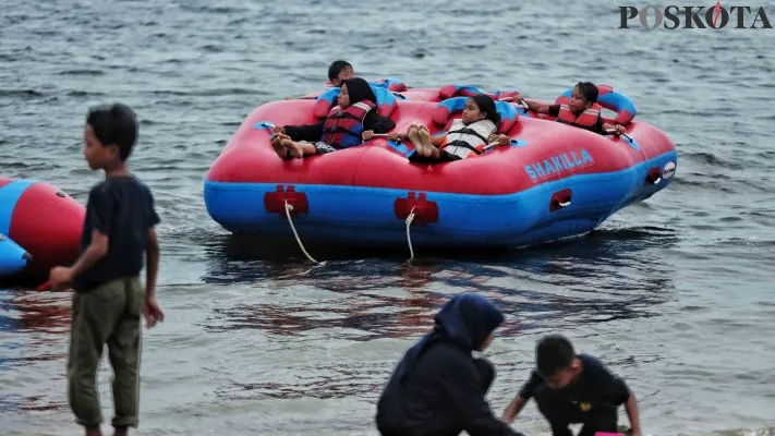 Sejumlah pengunjung Ancol tengah asyik bermain di Pantai untuk mengisi waktu libur. (dok poskota)