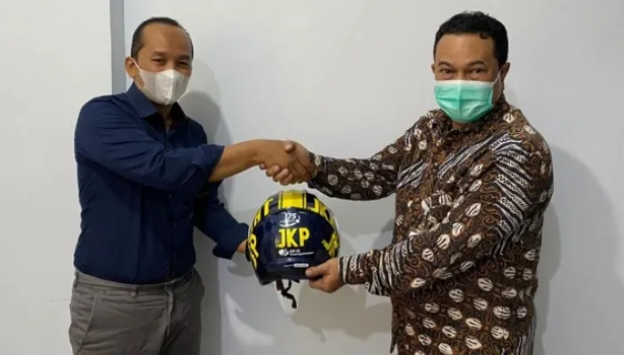 Chairul Arianto Kepala Kantor BPJAMSOSTEK Jakarta Gambir menyerahkan bantuan Helm pada Wahyu Hidayat, HR Manager PT. Maximus Integrasi Indonesia.(Ist)