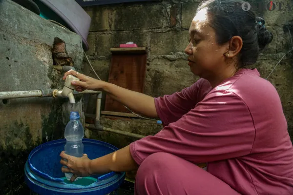 Sejumlah warga RT 02 RW 12 Lagoa dan RT 05 RW 05 Cilincing saat memperlihatkan perbandingan air minum kemasan (kiri) dan air PAM yng tidak layak konsumsi di kawasan Jakarta Utara, Rabu, 18 Desember 2024. (Poskota/ Ahmad Tri Hawaari)