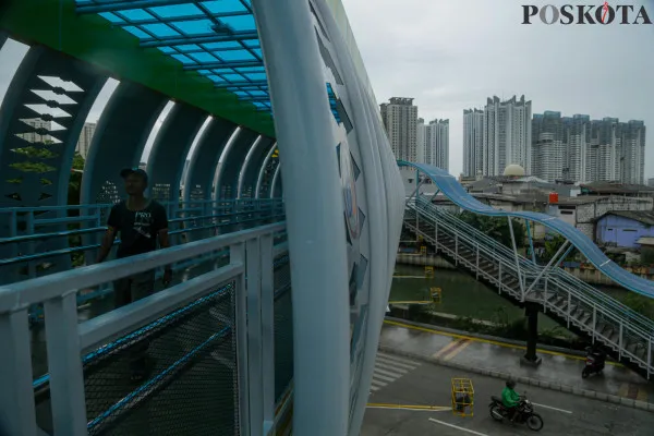 Warga saat melintasi Jembatan Penyeberangan Orang (JPO) Sunter Muara, Sunter, Jakarta Utara, Rabu, 18 Desember 2024. (Poskota/ Ahmad Tri Hawaari)