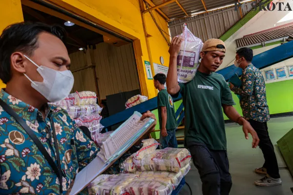 Pekerja saat merapikan dan memikul beras kemasan di Gudang Beras Food Stasiun Tjipinang, Jakarta Timur, Kamis, 19 Desember 2024. (Poskota/ Ahmad Tri Hawaari)