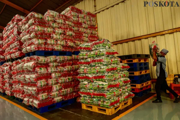 Pekerja saat merapikan dan memikul beras kemasan di Gudang Beras Food Stasiun Tjipinang, Jakarta Timur, Kamis, 19 Desember 2024. (Poskota/ Ahmad Tri Hawaari)