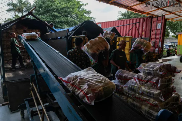 Pekerja saat merapikan dan memikul beras kemasan di Gudang Beras Food Stasiun Tjipinang, Jakarta Timur, Kamis, 19 Desember 2024. (Poskota/ Ahmad Tri Hawaari)