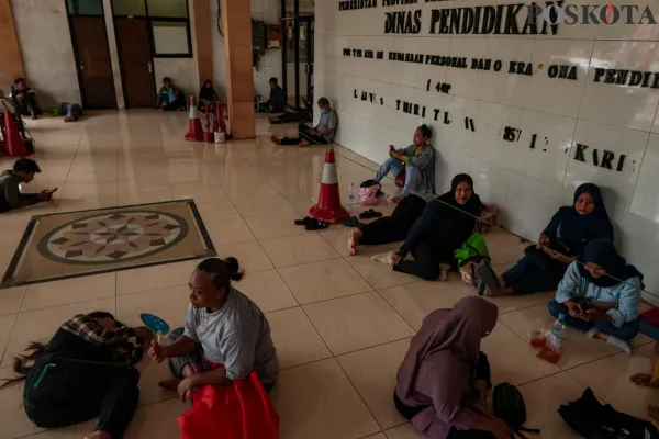 Sejumlah orang tua peserta didik saat menunggu antrean pengaduan terkait pembatalan KJP Plus di Kantor Dinas Pendidikan Unit Pelayanan Pendanaan Personal dan Operasional Pendidikan, Rawa Bunga, Jatinegara Timur, Jakarta Timur, Kamis, 19 Desember 2024. (Poskota/ Ahmad Tri Hawaari)