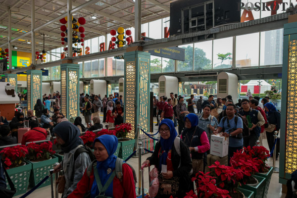 Penumpang kereta api membawa barang bawaannya di Stasiun Pasar Senen, Senen, Jakarta Pusat, Jumat, 20 Desember 2024. (Poskota/ Ahmad Tri Hawaari)