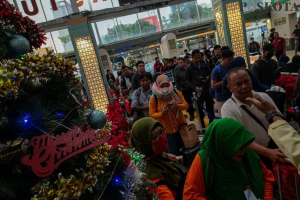 Calon penumpang kereta api saat mengantre sambil membawa barang bawaannya di area pintu masuk dan ruang tunggu sesaat sebelum keberangkatan saat arus mudik jelang libur Nataru di Stasiun Pasar Senen, Senen, Jakarta Pusat, Jumat, 20 Desember 2024. (Poskota/ Ahmad Tri Hawaari)