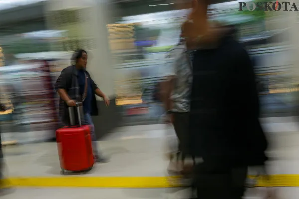 Calon penumpang kereta api saat mengantre sambil membawa barang bawaannya di area pintu masuk dan ruang tunggu sesaat sebelum keberangkatan saat arus mudik jelang libur Nataru di Stasiun Pasar Senen, Senen, Jakarta Pusat, Jumat, 20 Desember 2024. (Poskota/ Ahmad Tri Hawaari)