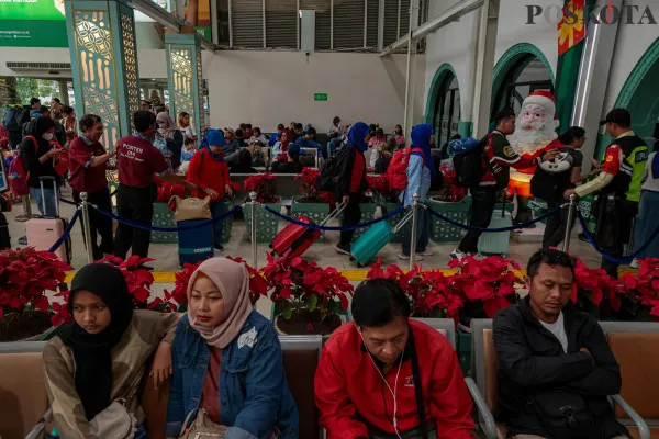 Calon penumpang kereta api saat mengantre sambil membawa barang bawaannya di area pintu masuk dan ruang tunggu sesaat sebelum keberangkatan saat arus mudik jelang libur Nataru di Stasiun Pasar Senen, Senen, Jakarta Pusat, Jumat, 20 Desember 2024. (Poskota/ Ahmad Tri Hawaari)