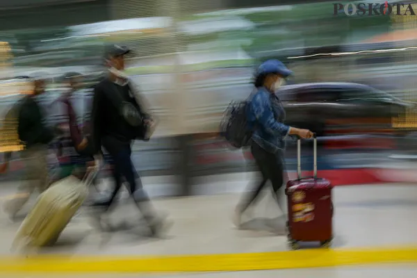 Calon penumpang kereta api saat mengantre sambil membawa barang bawaannya di area pintu masuk dan ruang tunggu sesaat sebelum keberangkatan saat arus mudik jelang libur Nataru di Stasiun Pasar Senen, Senen, Jakarta Pusat, Jumat, 20 Desember 2024. (Poskota/ Ahmad Tri Hawaari)
