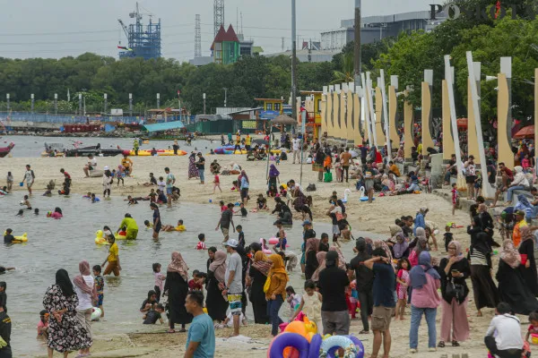 Sejumlah pengunjung memadati di Pantai Lagoon saat menikmati masa liburan Natal 2024 di  Ancol Taman Impian, Jakarta Utara, Rabu, 25 Desember 2024. (Poskota/ Ahmad Tri Hawaari)