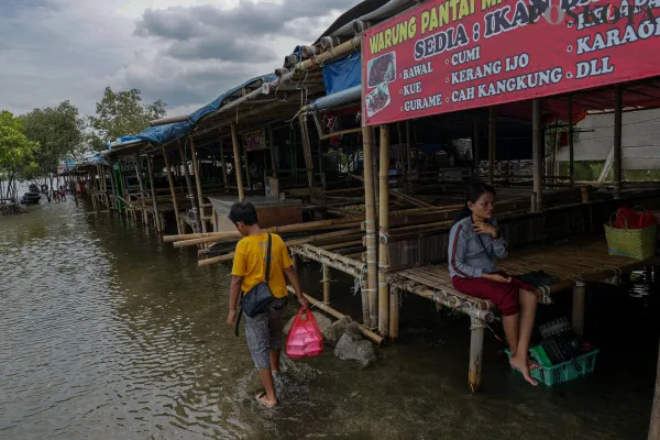 Sejumlah warga menikmati suasana pantai dengan berbagai aktivitas seperti berjalan di sisi pantai, berfoto hingga berenang di tengah banjir rob yang masih melanda di kawasan Pantai Marunda, Jakarta Utara, Kamis, 26 Desember 2024. (Poskota/ Ahmad Tri Hawaari)