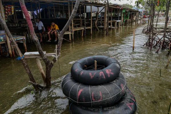 Sejumlah warga menikmati suasana pantai dengan berbagai aktivitas seperti berjalan di sisi pantai, berfoto hingga berenang di tengah banjir rob yang masih melanda di kawasan Pantai Marunda, Jakarta Utara, Kamis, 26 Desember 2024. (Poskota/ Ahmad Tri Hawaari)