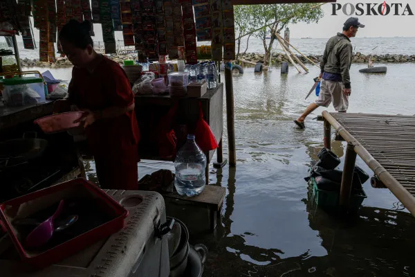 Sejumlah warga menikmati suasana pantai dengan berbagai aktivitas seperti berjalan di sisi pantai, berfoto hingga berenang di tengah banjir rob yang masih melanda di kawasan Pantai Marunda, Jakarta Utara, Kamis, 26 Desember 2024. (Poskota/ Ahmad Tri Hawaari)