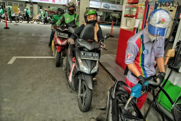 Foto : Petugas SPBU Pertamina sedang melakukan pengisian bahan bakar Pertamax ke pengemudi sepeda motor. (Poskota/Ahmad Tri Hawaari)