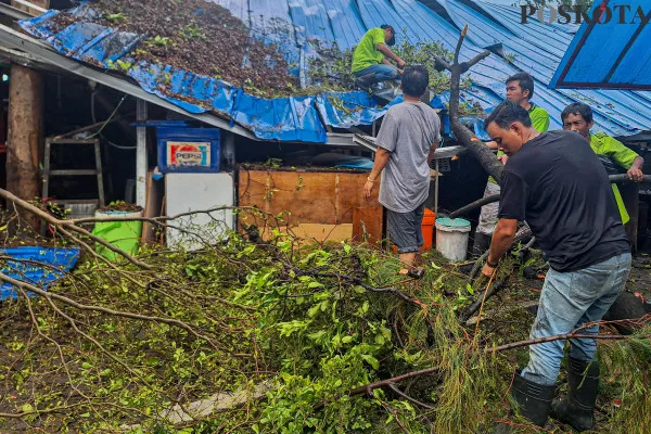Pedagang dan pekerja Senen Jaya saat proses evakuasi batang pohon yang tumbang menimpa kantin akibat angin kencang di Pasar Senen, Jakarta Pusat, Senin, 2 Desember 2024. (Poskota/ Ahmad Tri Hawaari)