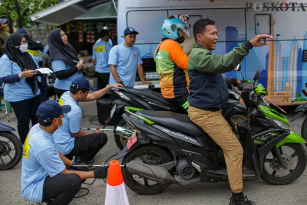 Petugas menguji emisi kendaraan saat gelaran Uji Emisi Gratis di Jalan Perintis Kemerdekaan, Kelapa Gading, Jakarta Utara, Selasa, 3 Desember 2024. (Poskota/ Ahmad Tri Hawaari)
