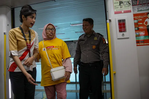 Petugas memandu penyandang disabilitas di Stasiun LRT Jakarta Velodrome, Rawamangun, Jakarta Timur, Selasa, 3 Desember 2024. (Poskota/ Ahmad Tri Hawaari)