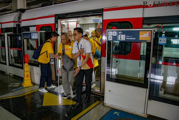 Petugas memandu penyandang disabilitas di Stasiun LRT Jakarta Velodrome, Rawamangun, Jakarta Timur, Selasa, 3 Desember 2024. (Poskota/ Ahmad Tri Hawaari)