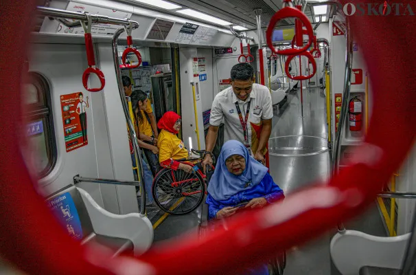 Petugas memandu penyandang disabilitas di Stasiun LRT Jakarta Velodrome, Rawamangun, Jakarta Timur, Selasa, 3 Desember 2024. (Poskota/ Ahmad Tri Hawaari)