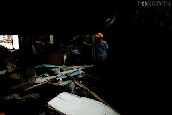 Proses evakuasi barang sisa bangunan yang dilakukan oleh sejumlah petugas di tengah aktivitas warga di kolong Tol Jembatan Tiga Pluit, Jakarta Utara, Senin, 9 Desember 2024. (Poskota/ Ahmad Tri Hawaari)