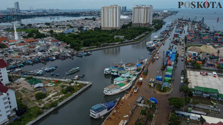 Aktivitas kendaraan dan buruh angkut kapal saat melintasi banjir rob yang melanda kawasan Pelabuhan Sunda Kelapa, Lodan Raya, Jakarta Utara, Minggu, 15 Desember 2024. (Poskota/ Ahmad Tri Hawaari)
