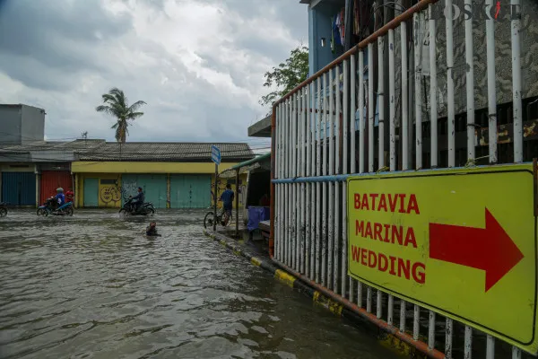Aktivitas kendaraan dan buruh angkut kapal saat melintasi banjir rob yang melanda kawasan Pelabuhan Sunda Kelapa, Lodan Raya, Jakarta Utara, Minggu, 15 Desember 2024. (Poskota/ Ahmad Tri Hawaari)