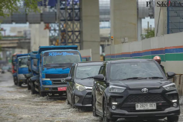 Sejumlah kendaraan saat menerobos banjir rob dan petugas rel kereta api saat mengecek ketinggian air di kawasan Jakarta Internasional Stadium (JIS), Jalan R.E.Martadinata, Jakarta Utara, Minggu, 15 Desember 2024. (Poskota/ Ahmad Tri Hawaari)